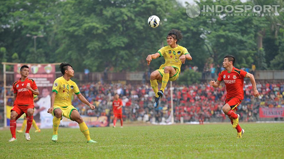 Rico Fernanda dari Cilegon United terbang menyambut bola lambung disaksikan oleh pemain Persibat Batang. Pertandingan dilaksanakan di lapangan sepakbola Krakatau Steel, Cilegon, Banten, Minggu (28/09/14).